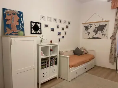 a small bedroom with a bed and a book shelf at Szlak Home in Kraków