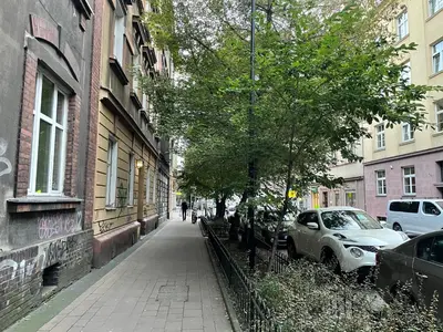 a street with cars parked on the side of a building at Szlak Home in Kraków