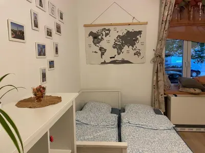 a room with two beds and a map on the wall at Szlak Home in Kraków
