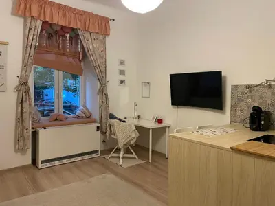 a kitchen with a table and a window with a desk at Szlak Home in Kraków