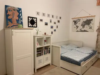 a bedroom with a bed and a book shelf at Szlak Home in Kraków