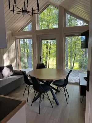 a living room with a wooden table and chairs at Domki nad Krzyworzeką in Dobczyce
