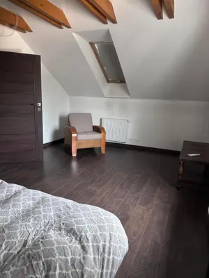 a bedroom with a bed and a chair at Domek na Krakowskiej in Kęty