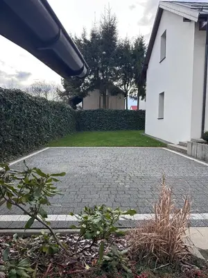 a brick driveway in front of a white house at Domek na Krakowskiej in Kęty
