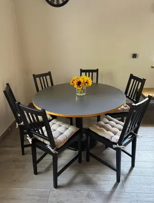 a dining room table with chairs and a vase of flowers at Domek na Krakowskiej in Kęty