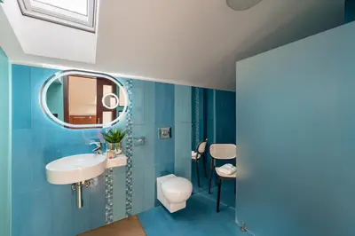 a blue bathroom with a sink and a mirror at Dome View Apartment by the Main Square - by Upstairs in Kraków
