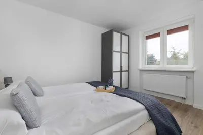 a white bedroom with a large white bed and a window at A Unique House with a Terrace and Garden in Cracow for 8 People by Noclegi Renters in Kraków