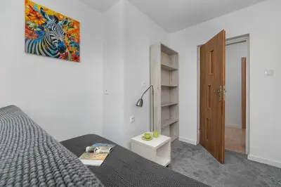 a bedroom with a bed and a wooden door at A Unique House with a Terrace and Garden in Cracow for 8 People by Noclegi Renters in Kraków