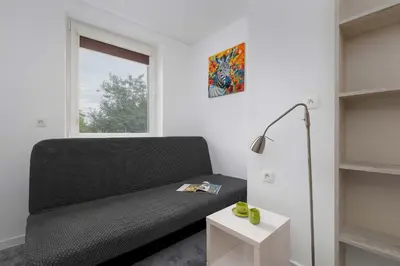a black couch in a room with a window at A Unique House with a Terrace and Garden in Cracow for 8 People by Noclegi Renters in Kraków