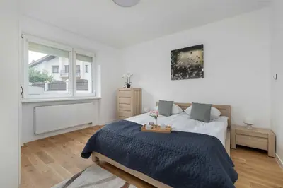 a white bedroom with a bed and a window at A Unique House with a Terrace and Garden in Cracow for 8 People by Noclegi Renters in Kraków