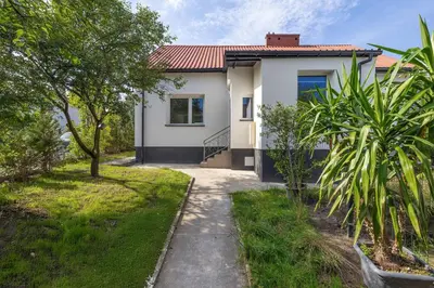 a white house with a pathway in front of it at A Unique House with a Terrace and Garden in Cracow for 8 People by Noclegi Renters in Kraków