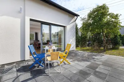 a patio with chairs and a table on a patio at A Unique House with a Terrace and Garden in Cracow for 8 People by Noclegi Renters in Kraków