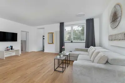 a white living room with a couch and a table at A Unique House with a Terrace and Garden in Cracow for 8 People by Noclegi Renters in Kraków