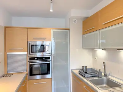 a kitchen with stainless steel appliances and wooden cabinets at Fabryczna City Residence 100m2 Balcony by Gio Loft in Kraków