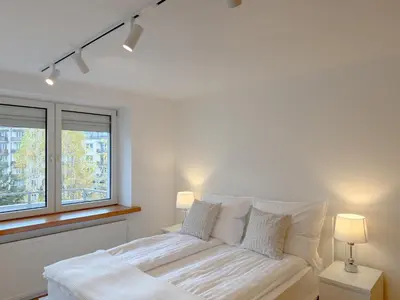 a white bed in a room with two windows at Fabryczna City Residence 100m2 Balcony by Gio Loft in Kraków