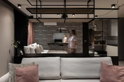 a living room with a couch and a person in the background at Kraków Wawrzyńca Suites by Downtown Apartments in Kraków