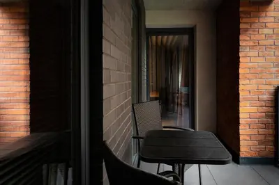 a chair sitting on a porch next to a brick wall at Kraków Wawrzyńca Suites by Downtown Apartments in Kraków