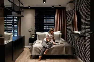 a woman sitting on a bed in a room at Kraków Wawrzyńca Suites by Downtown Apartments in Kraków