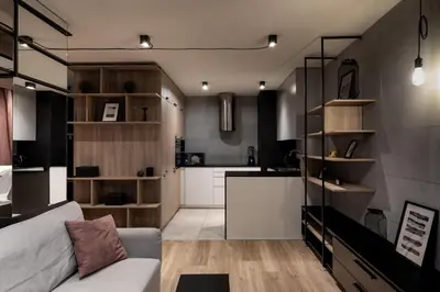 a living room with a couch and a kitchen at Kraków Wawrzyńca Suites by Downtown Apartments in Kraków