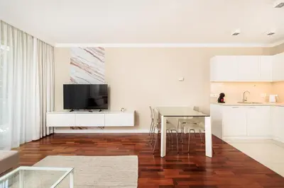 a living room with a table and a kitchen at City of the Kings - Solaris Apartment in Kraków