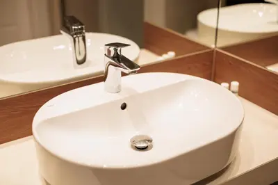 a white sink in a bathroom with a mirror at City of the Kings - Solaris Apartment in Kraków