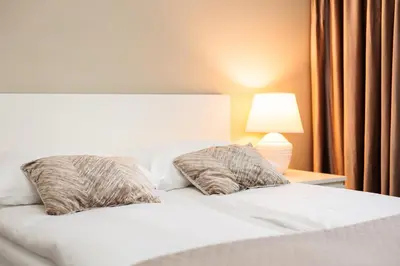 a bedroom with a white bed with two pillows at City of the Kings - Solaris Apartment in Kraków