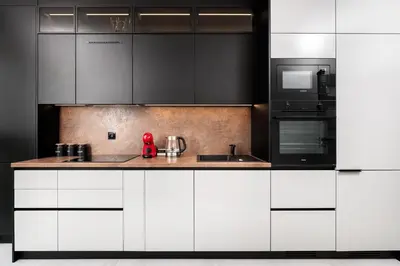a kitchen with white cabinets and a red appliance at City of the Kings - Eden Apartment in Kraków