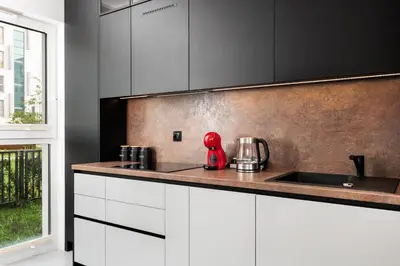 a kitchen with white cabinets and a red appliance on the counter at City of the Kings - Eden Apartment in Kraków