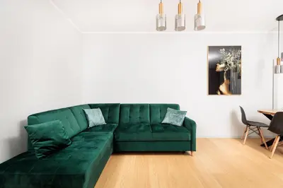 a green couch in a living room with a table at City of the Kings - Eden Apartment in Kraków