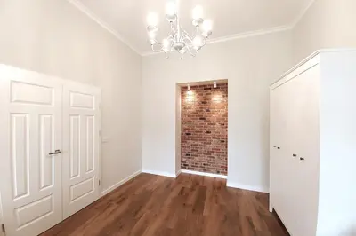 an empty room with a brick wall and a chandelier at Krakowska Street Old Town Apt 16 in Kraków