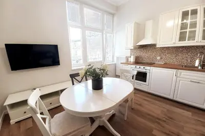 a kitchen with a white table and a white table and chairs at Krakowska Street Old Town Apt 16 in Kraków