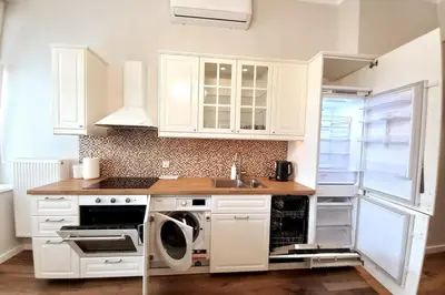 a kitchen with white cabinets and a washer at Krakowska Street Old Town Apt 16 in Kraków