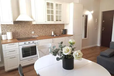 a kitchen with a table with a vase of flowers on it at Krakowska Street Old Town Apt 16 in Kraków