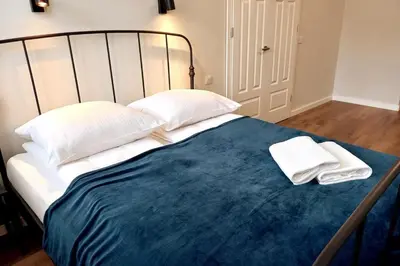 a bed with two white pillows and a blue blanket at Krakowska Street Old Town Apt 16 in Kraków