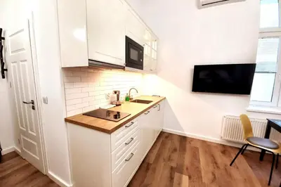 a white kitchen with a sink and a microwave at Krakowska Street Old Town Apt 16a in Kraków