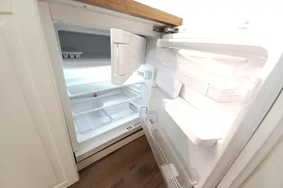 an empty refrigerator with its door open in a kitchen at Krakowska Street Old Town Apt 16a in Kraków