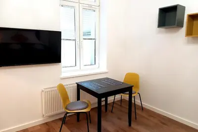 a table and chairs in a room with a window at Krakowska Street Old Town Apt 16a in Kraków