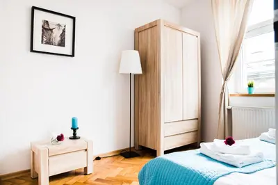 a white room with two beds and a lamp at 3D Royal Castle Apartament in Kraków