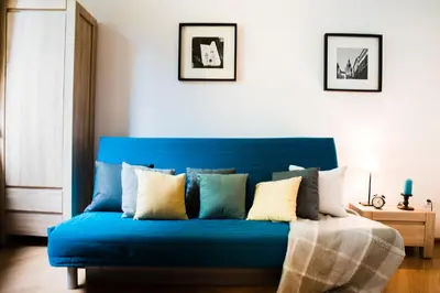 a blue couch with pillows on it in a room at 3D Royal Castle Apartament in Kraków
