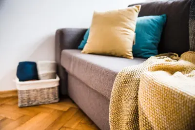 a couch with a blanket on it in a living room at 3D Royal Castle Apartament in Kraków