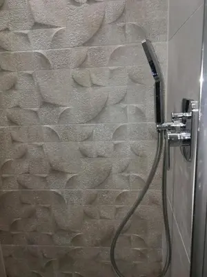 a shower with a hose attached to a stone wall at 3D Royal Castle Apartament in Kraków
