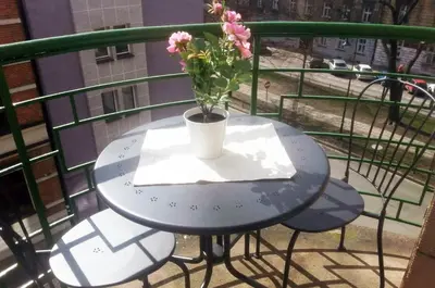 a blue table with a vase of flowers on a balcony at 3D Royal Castle Apartament in Kraków