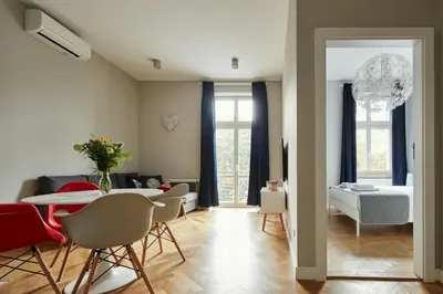 a living room with a table and chairs and a bedroom at PlayRoom Aparthotel in Kraków