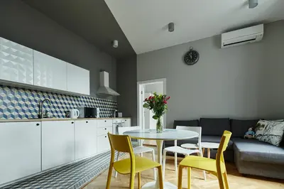 a kitchen and dining room with a table and chairs at PlayRoom Aparthotel in Kraków