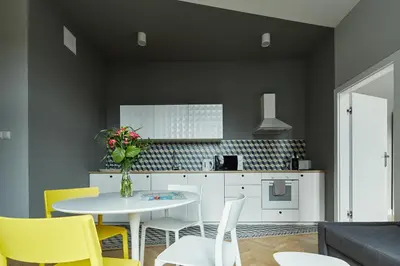 a kitchen with a table and yellow chairs at PlayRoom Aparthotel in Kraków