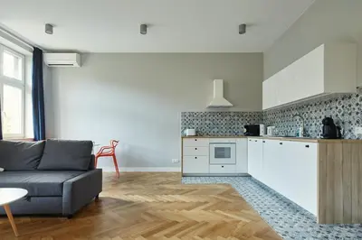 a living room with a couch and a kitchen at PlayRoom Aparthotel in Kraków
