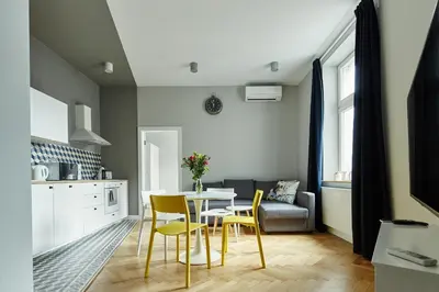 a kitchen and dining room with a table and chairs at PlayRoom Aparthotel in Kraków