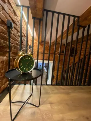 a clock sitting on a table in a room at Apartament Aria in Kraków
