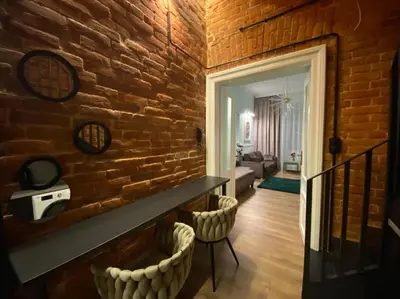 a living room with a brick wall and two chairs at Apartament Aria in Kraków