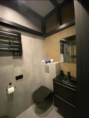 a bathroom with a black toilet and a sink at Apartament Aria in Kraków